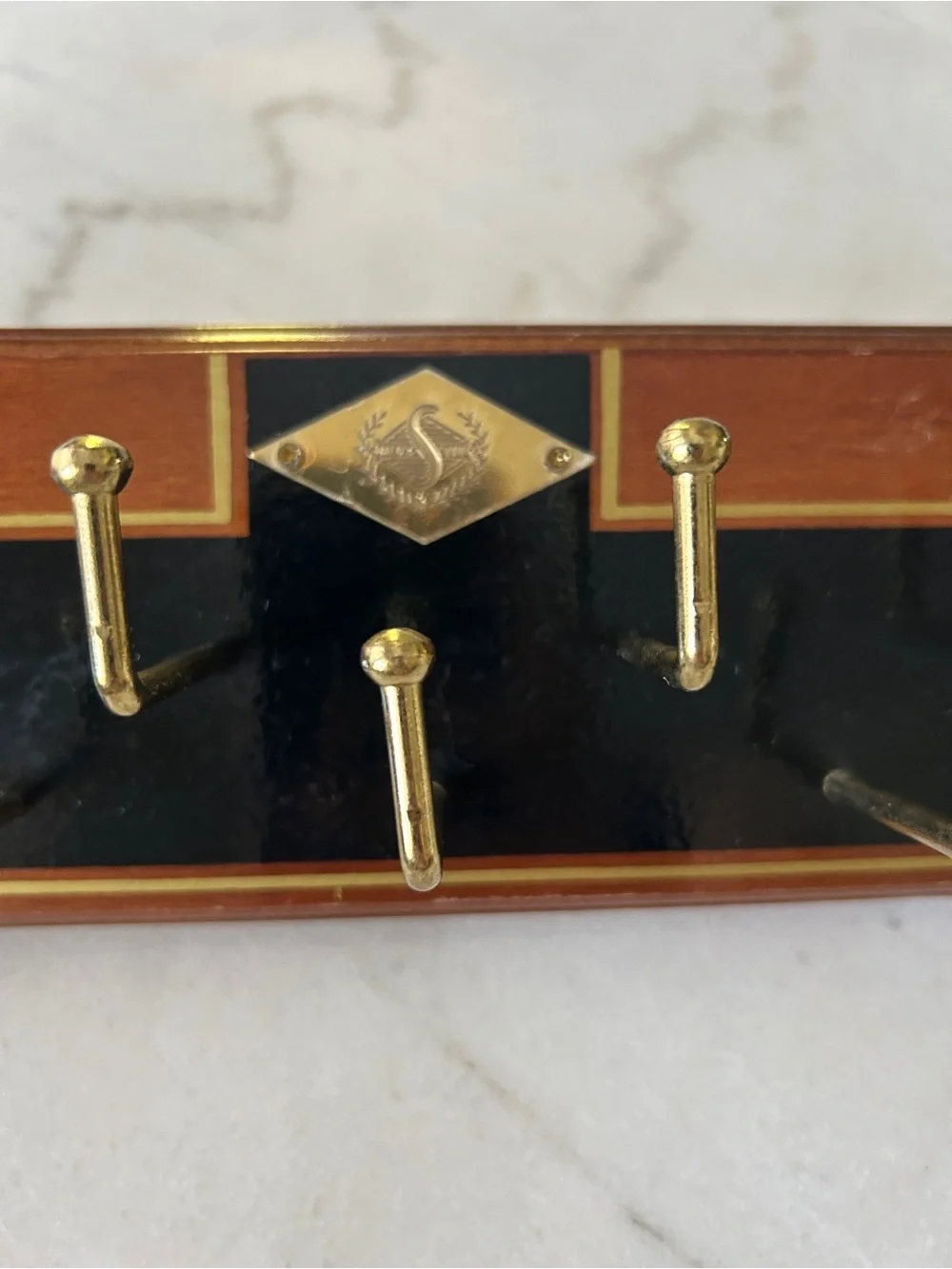 Vintage Wall-Mounted Tie Rack with Gold Hooks and Black Accent